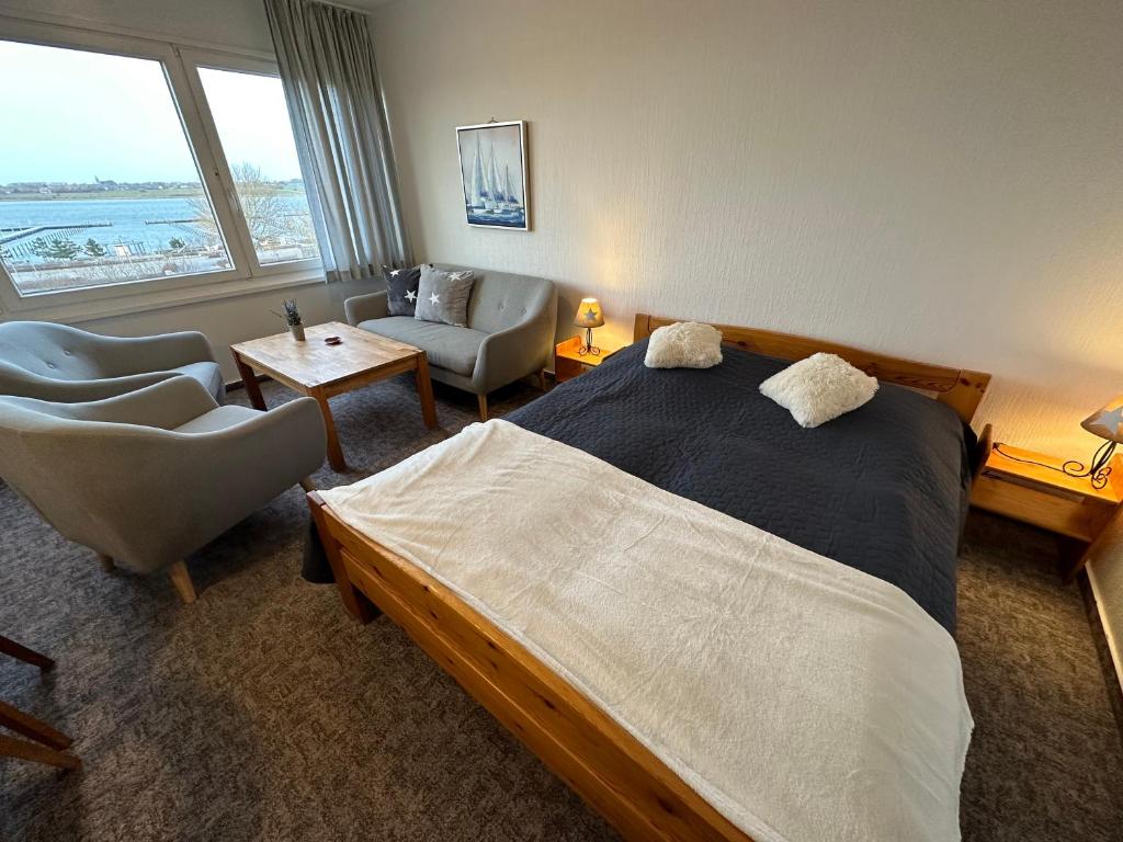 - une chambre avec un grand lit, un canapé et des chaises dans l'établissement Möwe, à Burgtiefe auf Fehmarn 