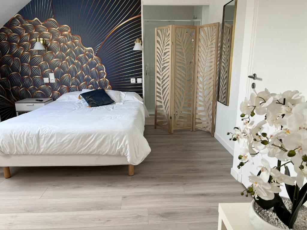 a bedroom with a white bed and a plant at Cœur de Loire in Pocé-sur-Cisse