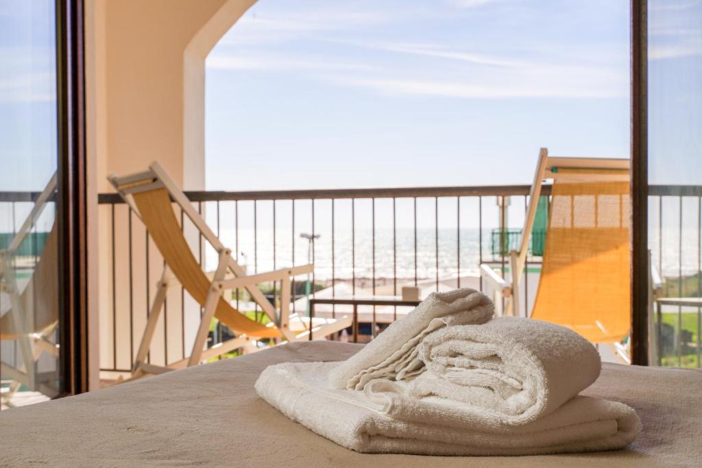 a towel on a bed with a view of the ocean at Smy Civico Zero in Tarquinia
