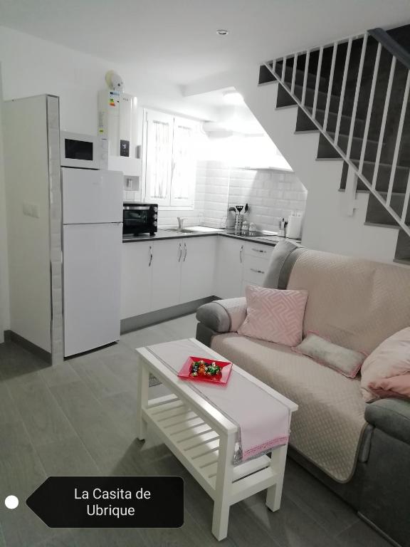 a living room with a couch and a table and a kitchen at La Casita de Ubrique in Ubrique