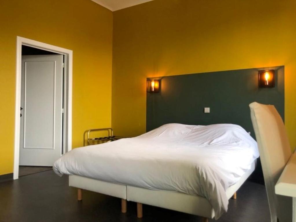 a bedroom with a bed with a green and yellow wall at Hotel Le Limbourg in Rochefort