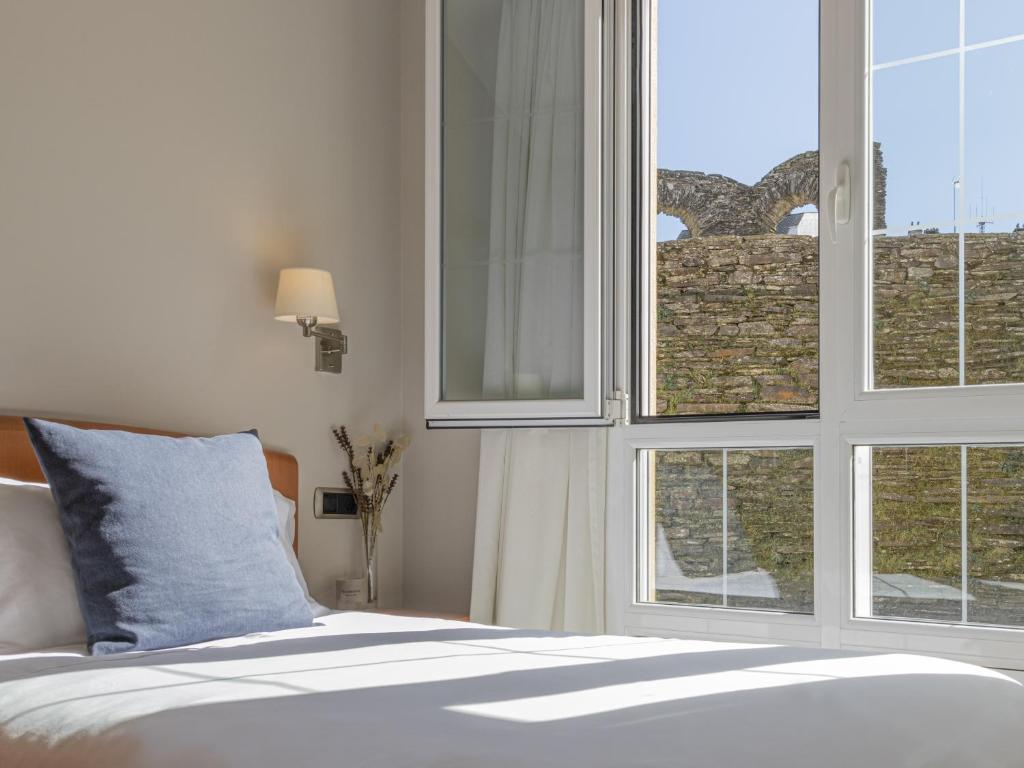 a bedroom with a bed and a window with a view at Hostal ALBA Lugo in Lugo