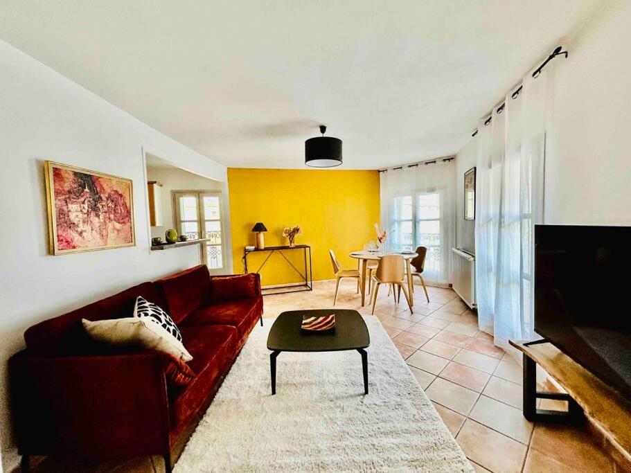 ein Wohnzimmer mit einem Sofa und einem Tisch in der Unterkunft Le Sébastopol -Très Bel appartement en plein centre de Beziers-Wifi in Béziers