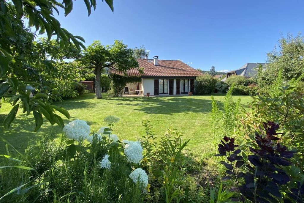a garden with a house in the background at Lovely house in a quiet place in Bôle