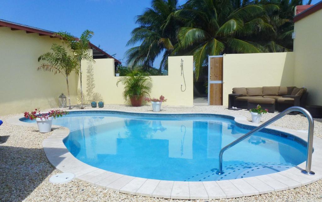 una gran piscina en un patio con sofá en Bubali Gardens, en Palm-Eagle Beach