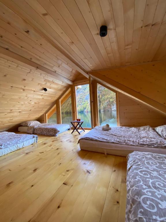 a room with four beds in a wooden house at Floating House Perućac in Perućac