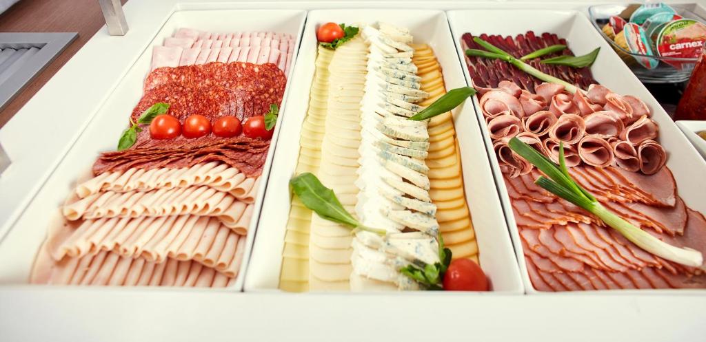 a refrigerator filled with different types of meats and cheese at Hotel Srbija Garden-FREE PARKING in Belgrade
