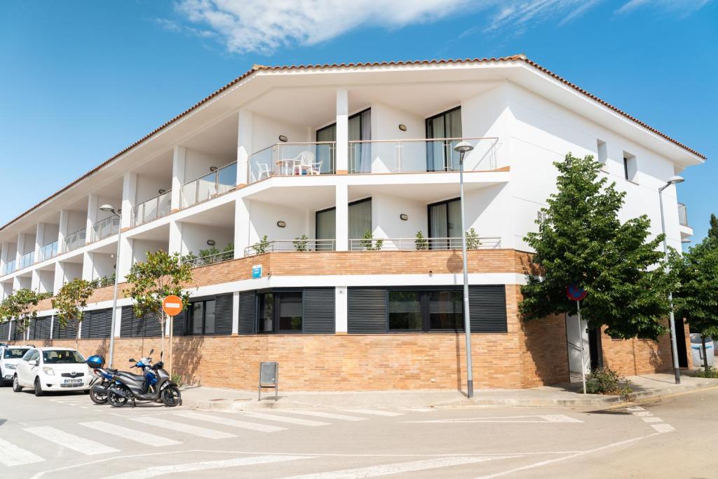 um grande edifício branco com estacionamento em Beatrix 2000 - Caliu apartments em Pineda de Mar