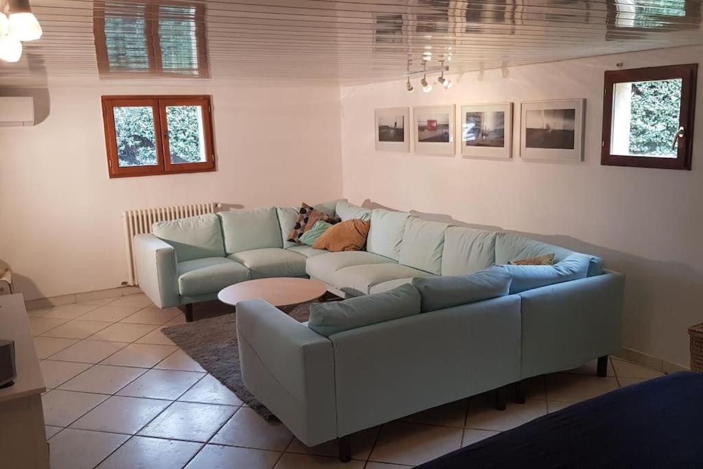 un salon avec un canapé et une table dans l'établissement Appartement de 50m2, climatisé avec terrasse et parking, à Castelnau-le-Lez