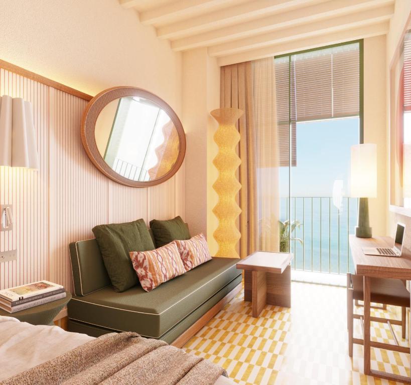 a bedroom with a green couch and a mirror at Hotel Casa Bassa in Valencia