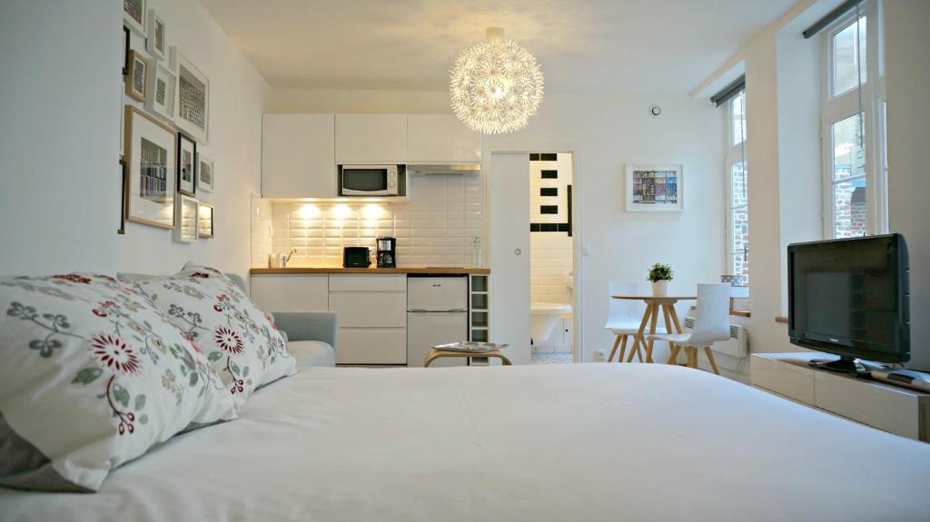 Habitación blanca con cama y TV en Little Suite - Oscar, en Lille