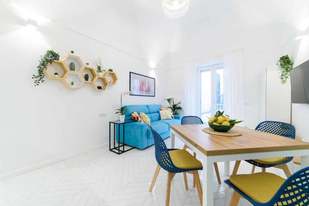 - un salon avec un canapé bleu et une table dans l'établissement Casa Andreana, à Amalfi