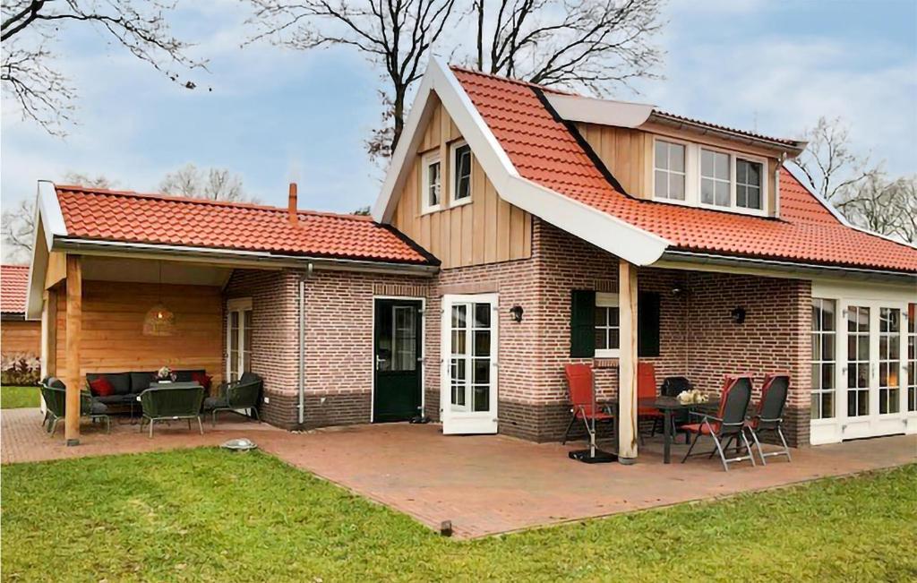 een huis met een rood dak en een patio bij 3 Bedroom Gorgeous Home In Hoge Hexel in Hoge-Hexel