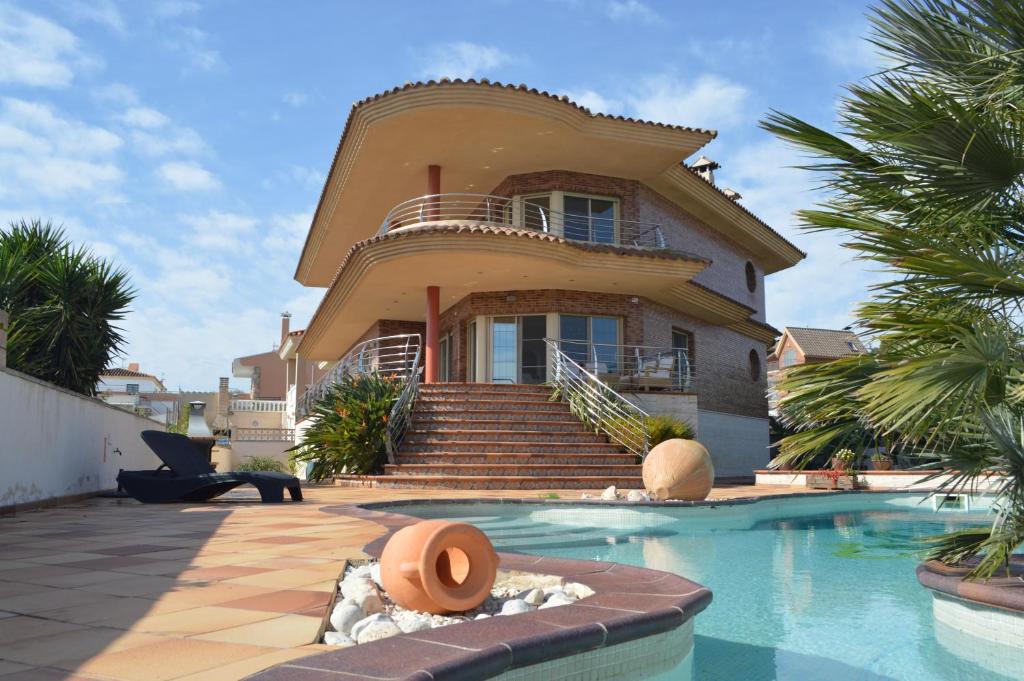 a house with a swimming pool in front of a house at Villa Mar i Vent in L'Ampolla