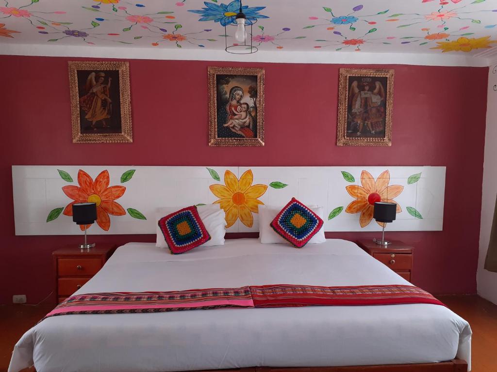 a bedroom with a bed with flowers on the wall at Reinbo Garden in Cusco