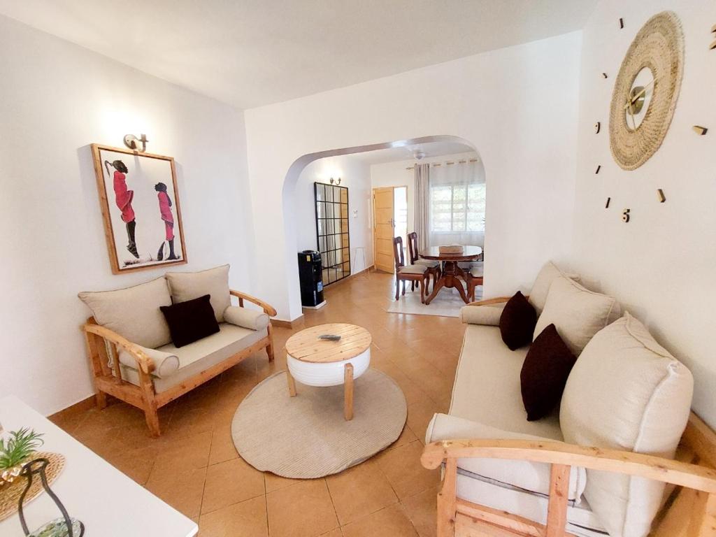 a living room with a couch and a table at Pinebreeze Holiday Resort in Nyali