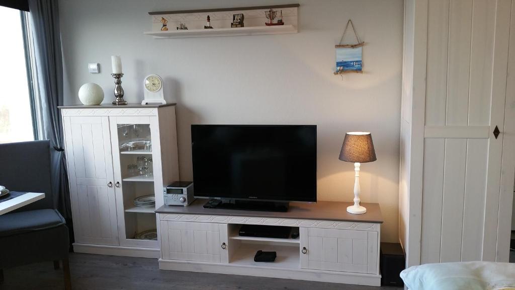 a living room with a television on a white entertainment center at FeWo Eggers 1 in Burgtiefe auf Fehmarn 