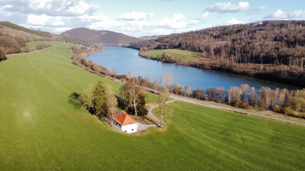 a house in a field next to a river at Villa Diemelsee in Diemelsee