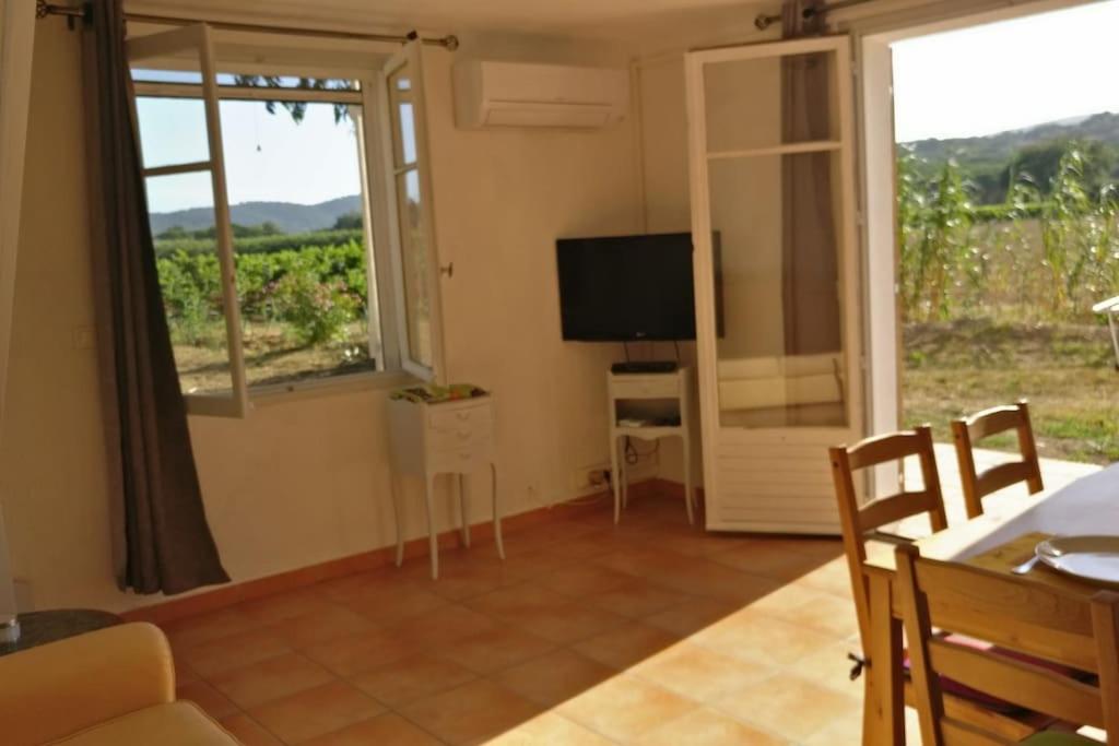 een woonkamer met een groot raam en een televisie bij LES VIGNES ET LA PINEDE PRES DE LA PLAGE in Saint-Tropez