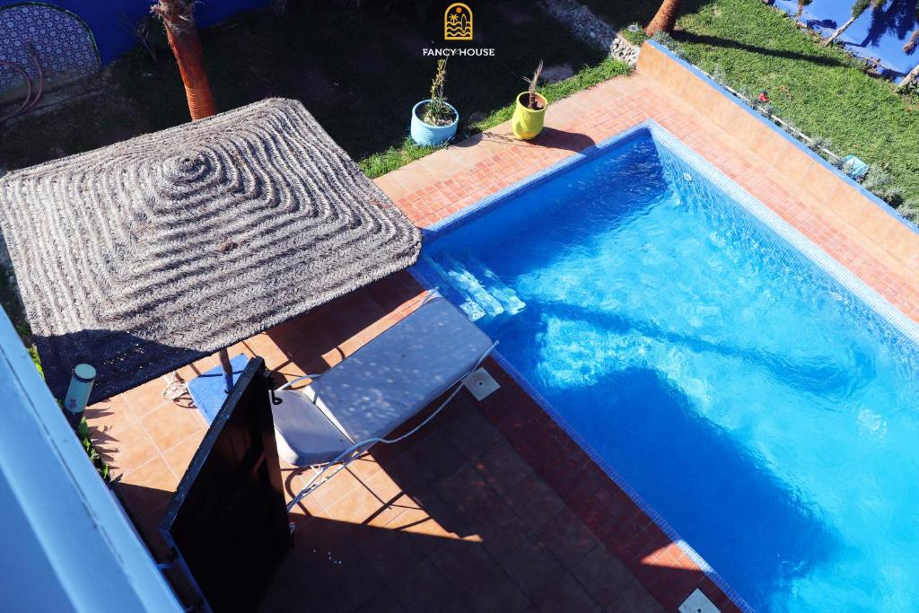 an overhead view of a swimming pool with a table and a chair at Fancy house in Oualidia
