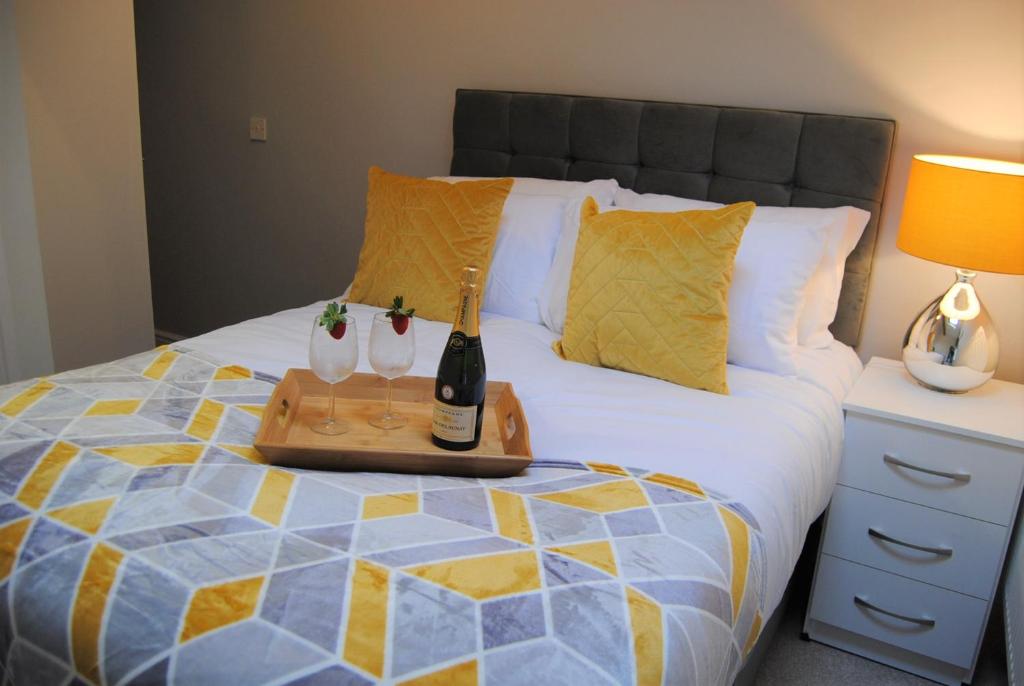 a bed with a tray with two bottles of wine at Quinta Cottage in Soutergate