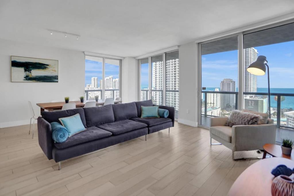 a living room with a couch and large windows at Condo 3 Bedrooms 2 min from the beach in Hallandale Beach