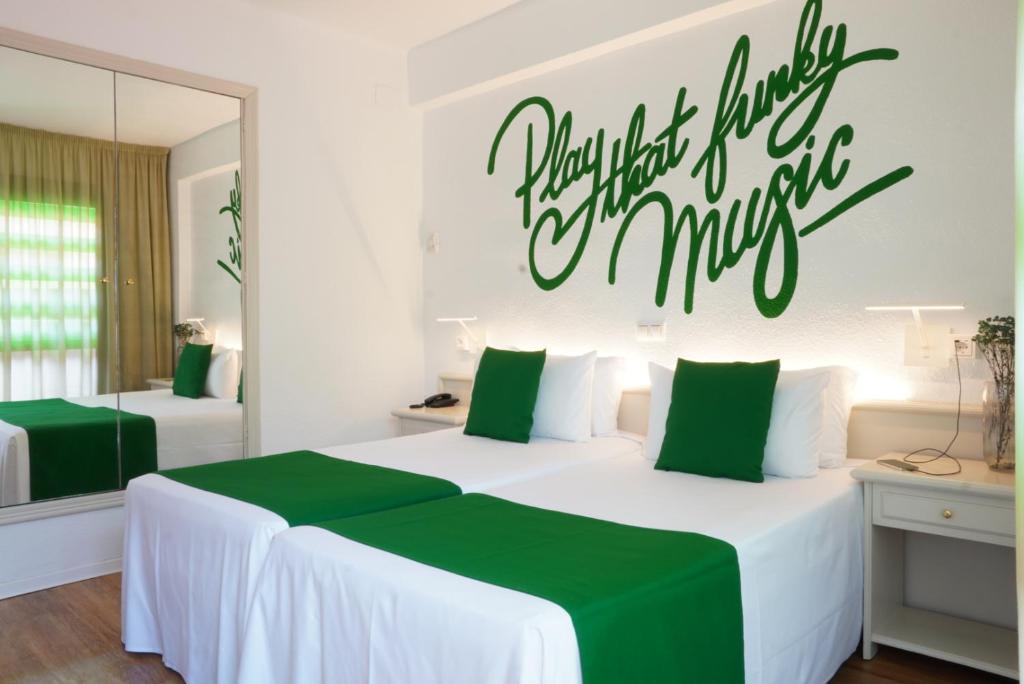 a bedroom with two beds with a sign on the wall at Lloret Vibe Affiliated by FERGUS in Lloret de Mar