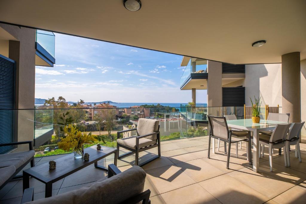 a living room with a table and chairs on a balcony at Agosta Sea View in Porticcio