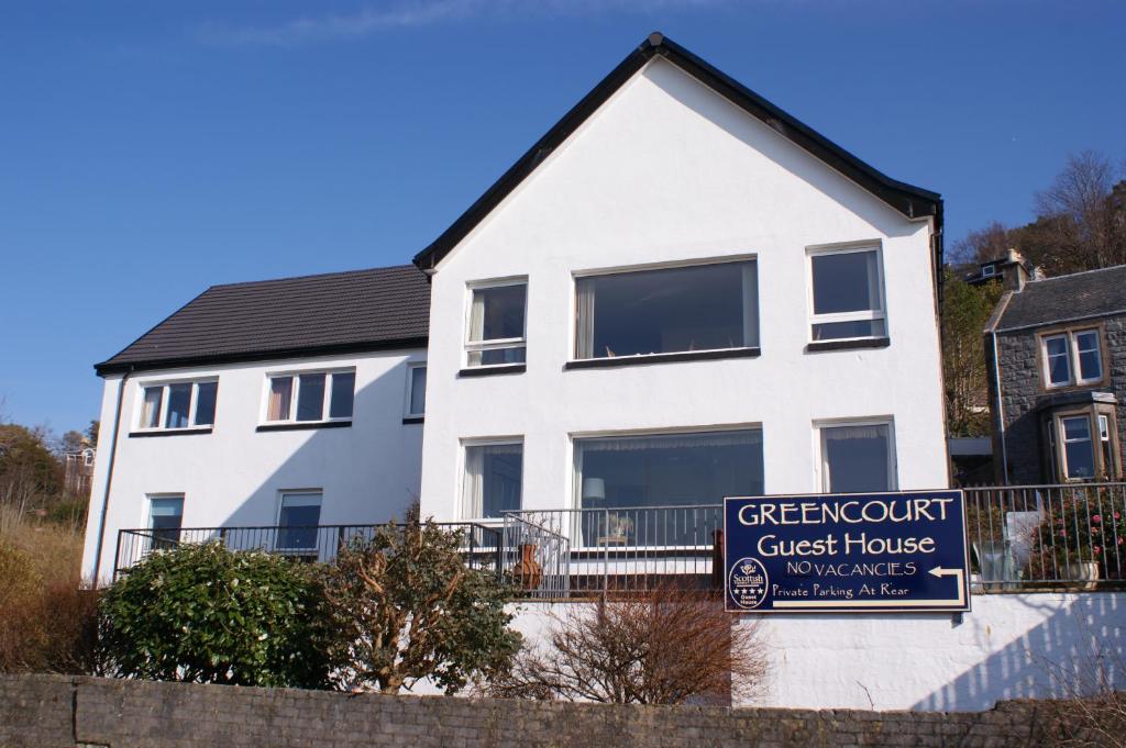 a white house with a sign in front of it at Greencourt Guest House in Oban