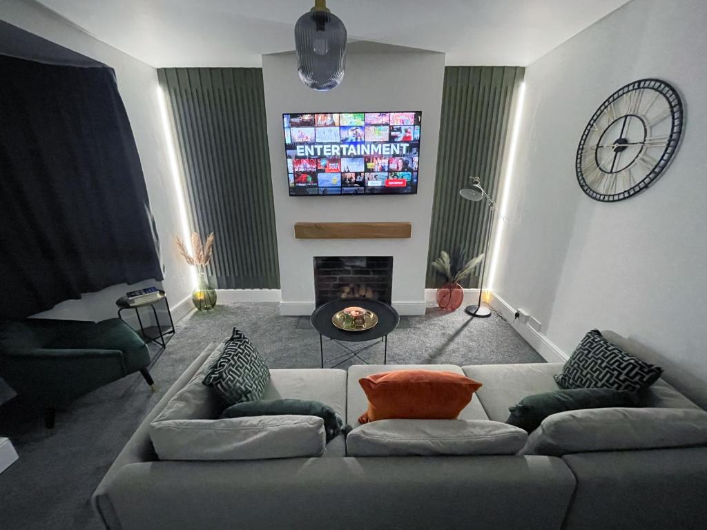 a living room with a couch and a tv at Tettenhall Village Townhouse in Wolverhampton