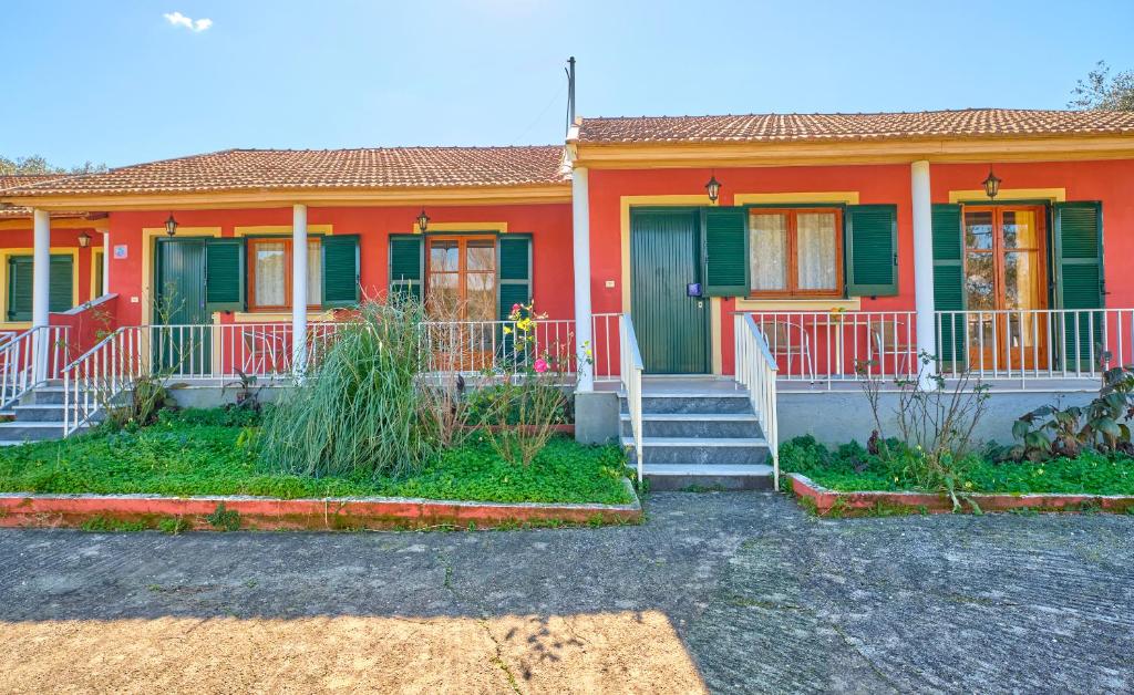 una casa con una casa naranja y verde en Theodora Apartments Agios Stefanos Corfu en Agios Stefanos