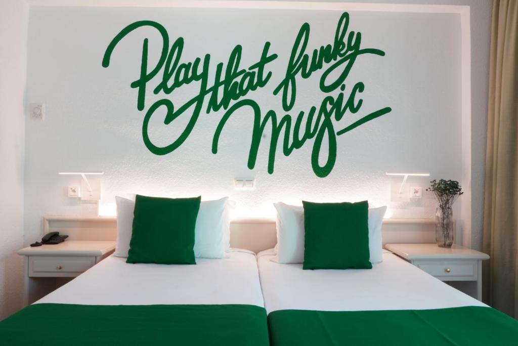 a bedroom with a bed with a sign that reads happy that there is a music at Lloret Vibe Affiliated by FERGUS in Lloret de Mar