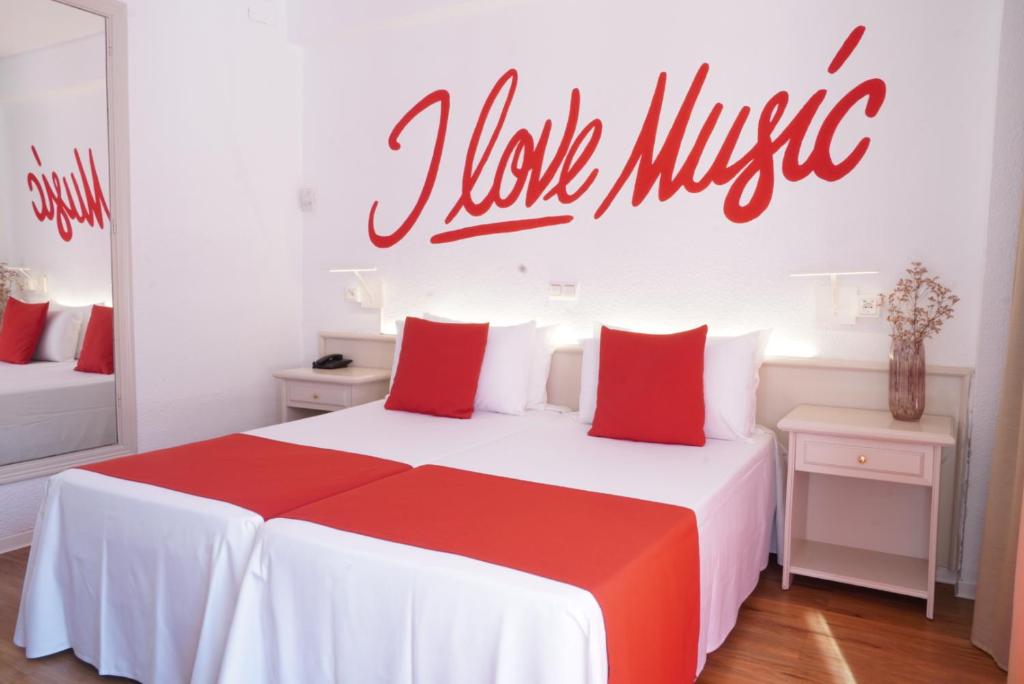 a bedroom with a red and white bed with a sign on the wall at Lloret Vibe Affiliated by FERGUS in Lloret de Mar
