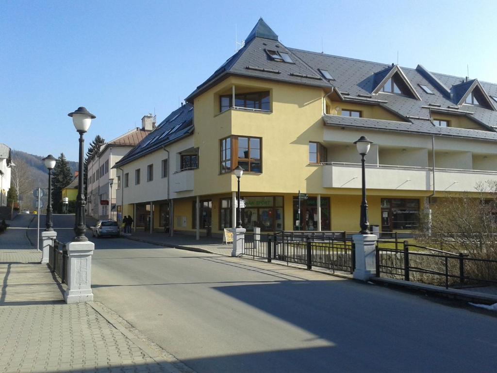 żółty budynek z czarnym dachem na ulicy w obiekcie Apartmán Edita w mieście Velké Losiny