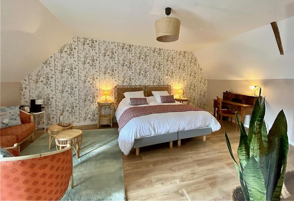 ein Schlafzimmer mit einem Bett, einem Sofa und einem Tisch in der Unterkunft Maison Alfred et Agatha in Pleudihen-sur-Rance