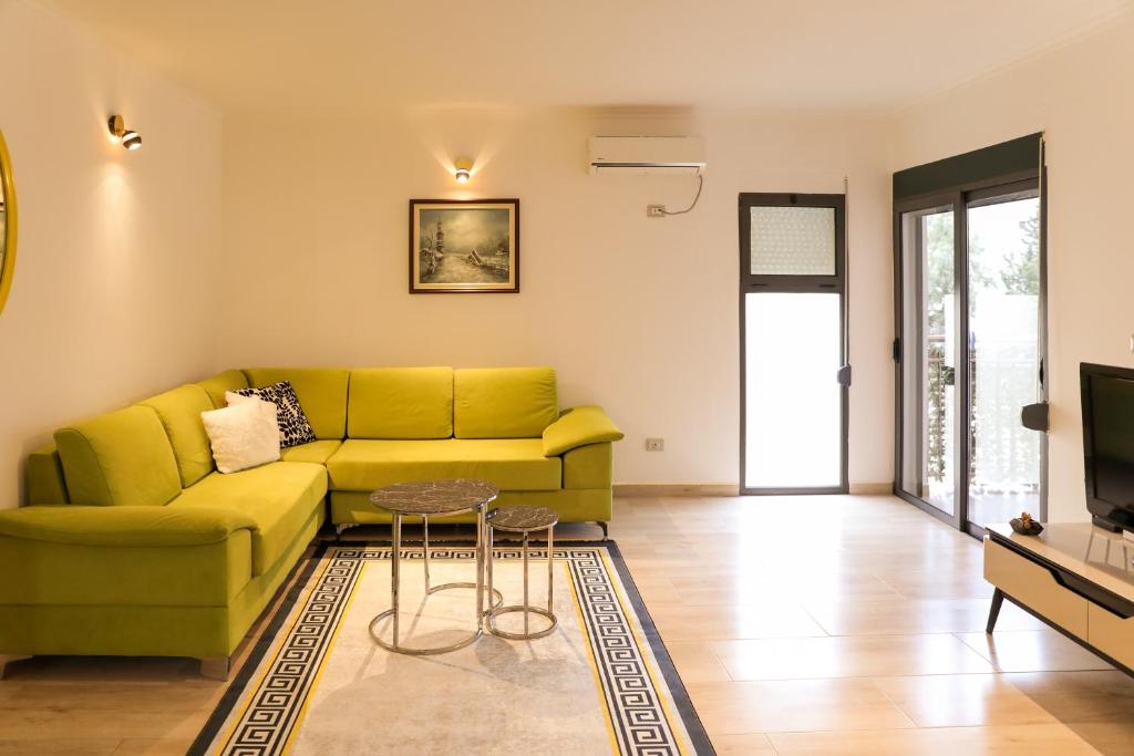uma sala de estar com um sofá amarelo e uma televisão em Melinda beach apartment em Golem