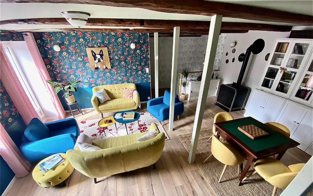 a living room with a couch and chairs and a table at Maison Alfred et Agatha in Pleudihen-sur-Rance