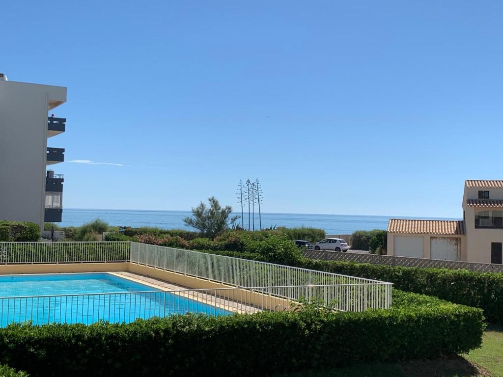 una piscina con vista sull'oceano sullo sfondo di Le Yachting vue mer a Le Barcarès