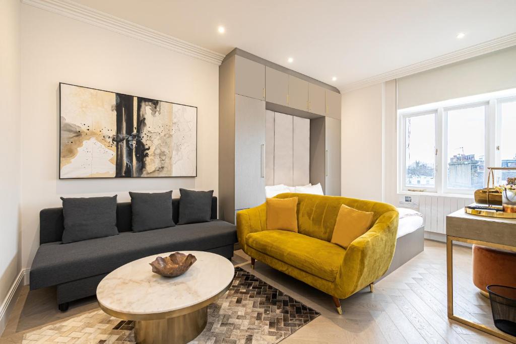 a living room with a couch and a yellow chair at Modern Apartments Near Harrods and the Science Museum in London