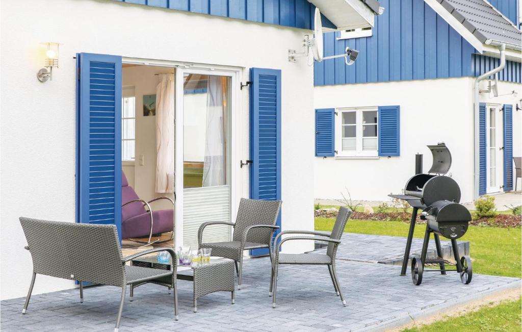 a patio with chairs and a grill in front of a house at Ferienhaus 32 Altefhr in Altefähr
