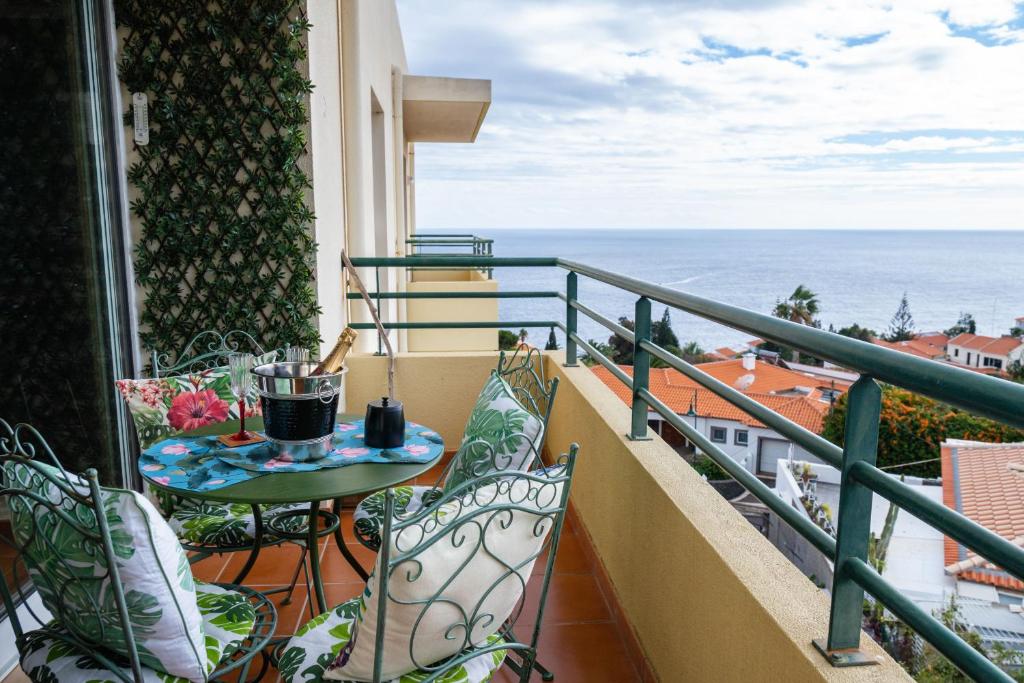 d'un balcon avec une table et des chaises donnant sur l'océan. dans l'établissement La Perle de Caniço by LovelyStay, à Santa Cruz