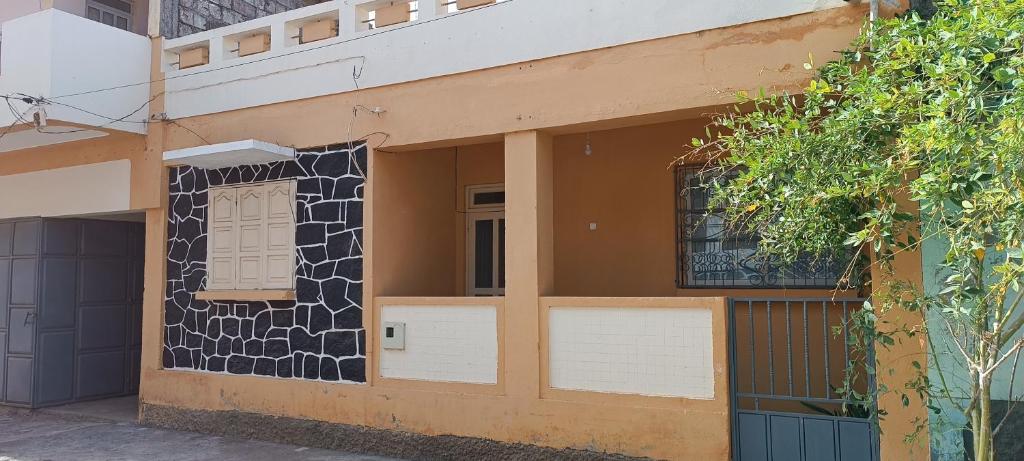 un edificio con una puerta y ventanas. en Casa de Férias en Tarrafal