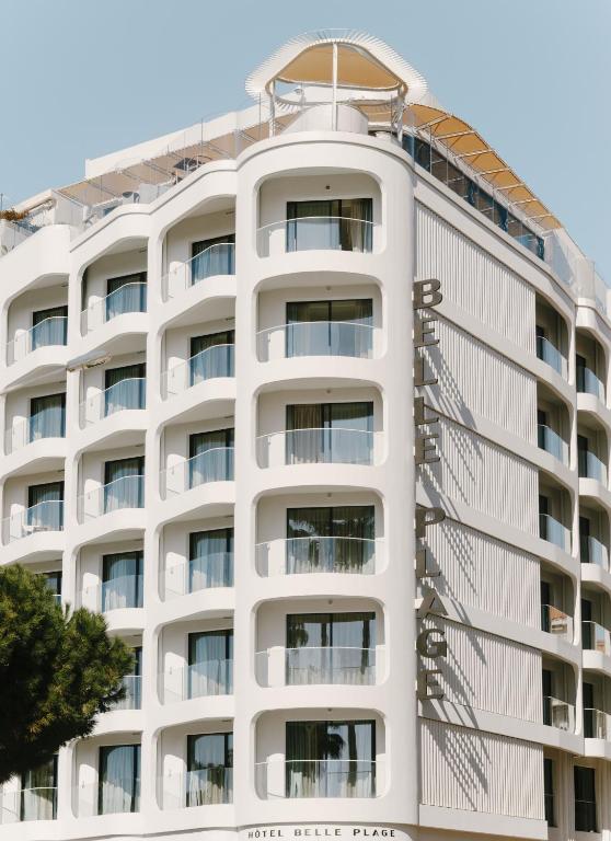 a white apartment building with a white facade at Hôtel & Spa Belle Plage in Cannes