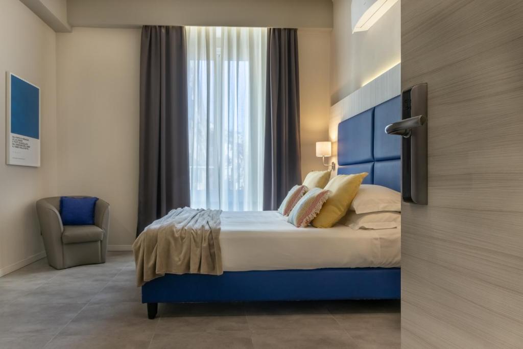 1 dormitorio con 1 cama con cabecero azul y ventana en Cinque Terre Gateway, en La Spezia
