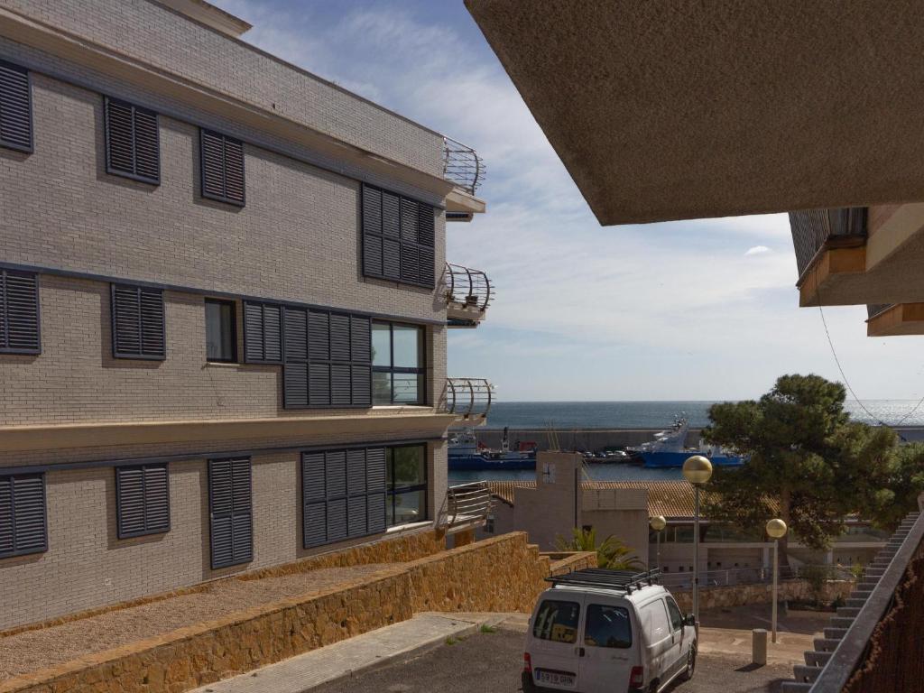 uma carrinha branca estacionada em frente a um edifício em INNOUTHOME Apartamento Ideal Vacaciones Mediterrani em L'Ametlla de Mar