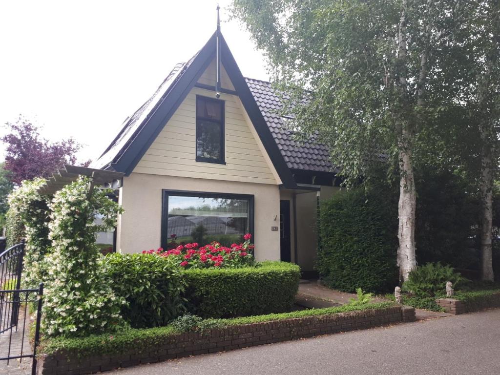 une maison avec des fleurs dans sa fenêtre dans l'établissement B&B Het Molensteegje, à Andijk