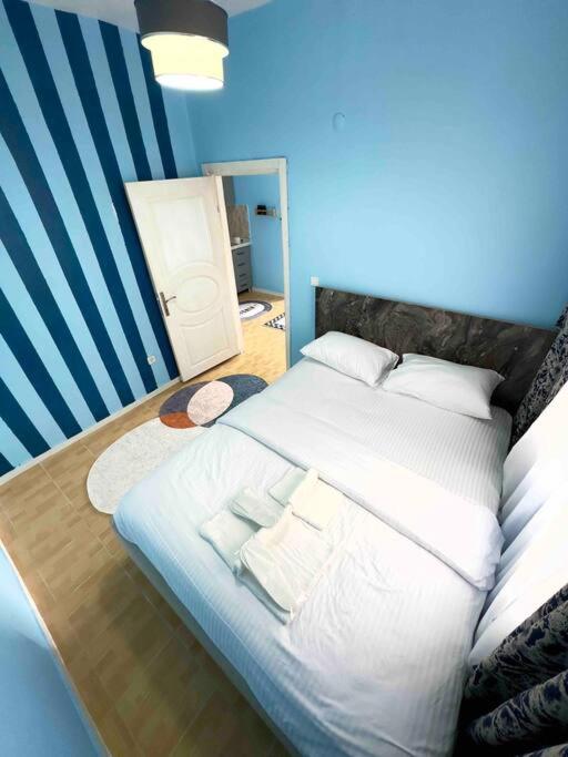 um quarto azul com uma cama grande e almofadas brancas em İstanbulun merkezinde şık 1+1 daire em Istambul