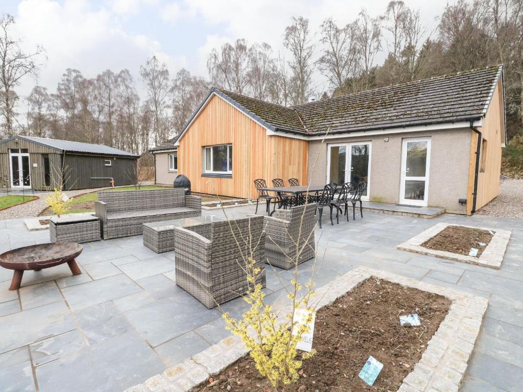 una casa y un patio con mesa y sillas en Mullingar, en Pitlochry