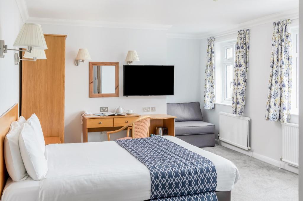 a hotel room with a bed and a desk and a chair at The Kilbirnie Hotel in Newquay