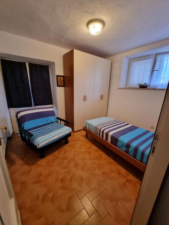 pokój z dwoma łóżkami i ławką w środku w obiekcie CASA GAIA - Limoncello - parcheggio privato incluso w mieście Levanto